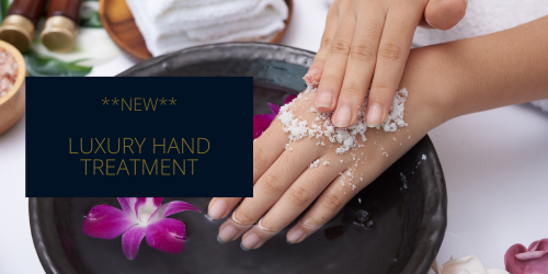 Salt scrub on hands in a bowl of water with a flower
